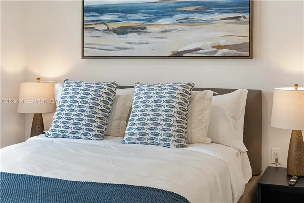 a bedroom with a bed and painting on the wall