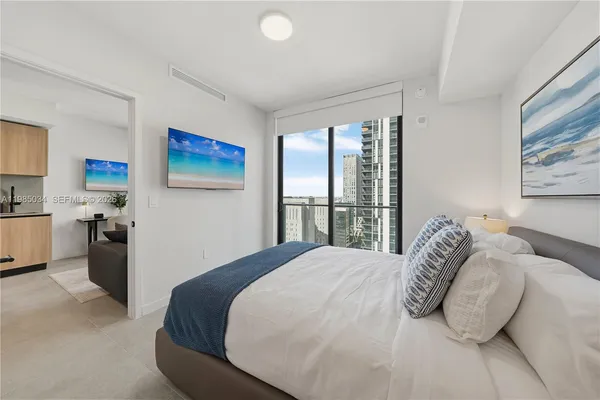 a bedroom with a bed and a painting on the wall