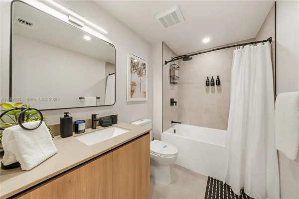 a bathroom with a granite countertop sink a toilet and shower