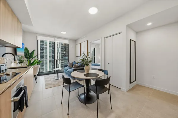 a view of a kitchen with kitchen island a table and chairs in it