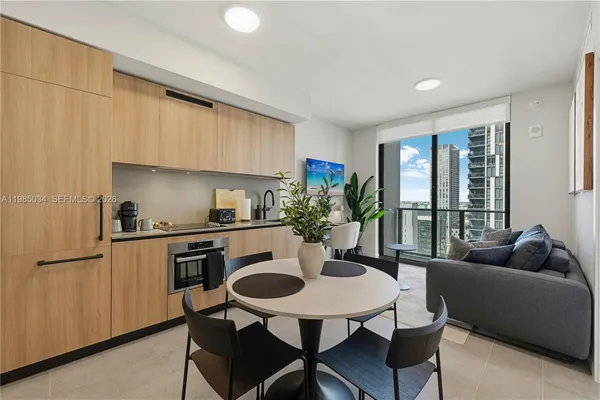 a kitchen with stainless steel appliances granite countertop a stove a sink a refrigerator white cabinets and furniture