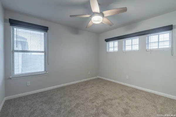 an empty room with a window and a fan