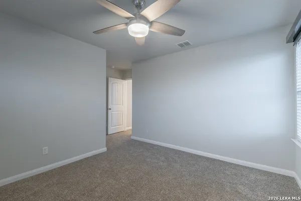 an empty room with a fan and a fan