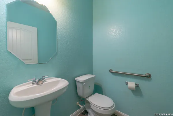 a bathroom with a sink a toilet and a mirror