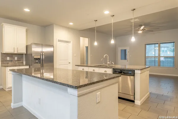 a kitchen with stainless steel appliances granite countertop a sink a oven and a refrigerator