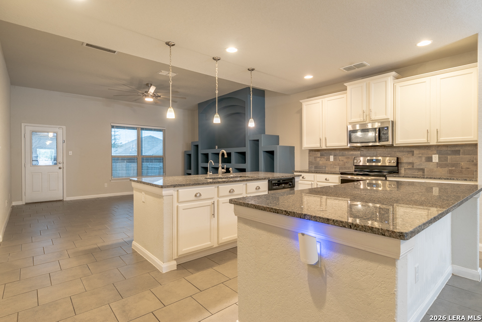 10230 Midsummer Meadow Converse, TX 78109 - Photo 10 of 37 a kitchen with stainless steel appliances granite countertop a sink stove and cabinets
