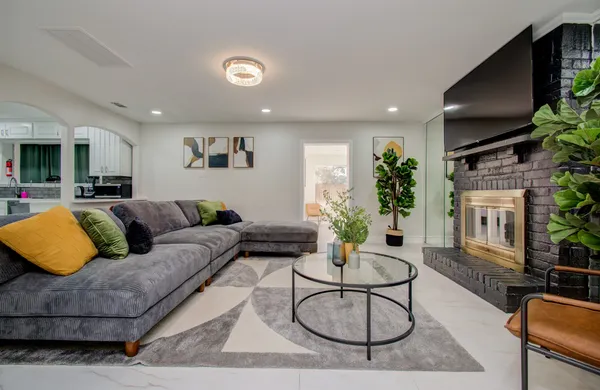 a living room with furniture a flat screen tv and a potted plant