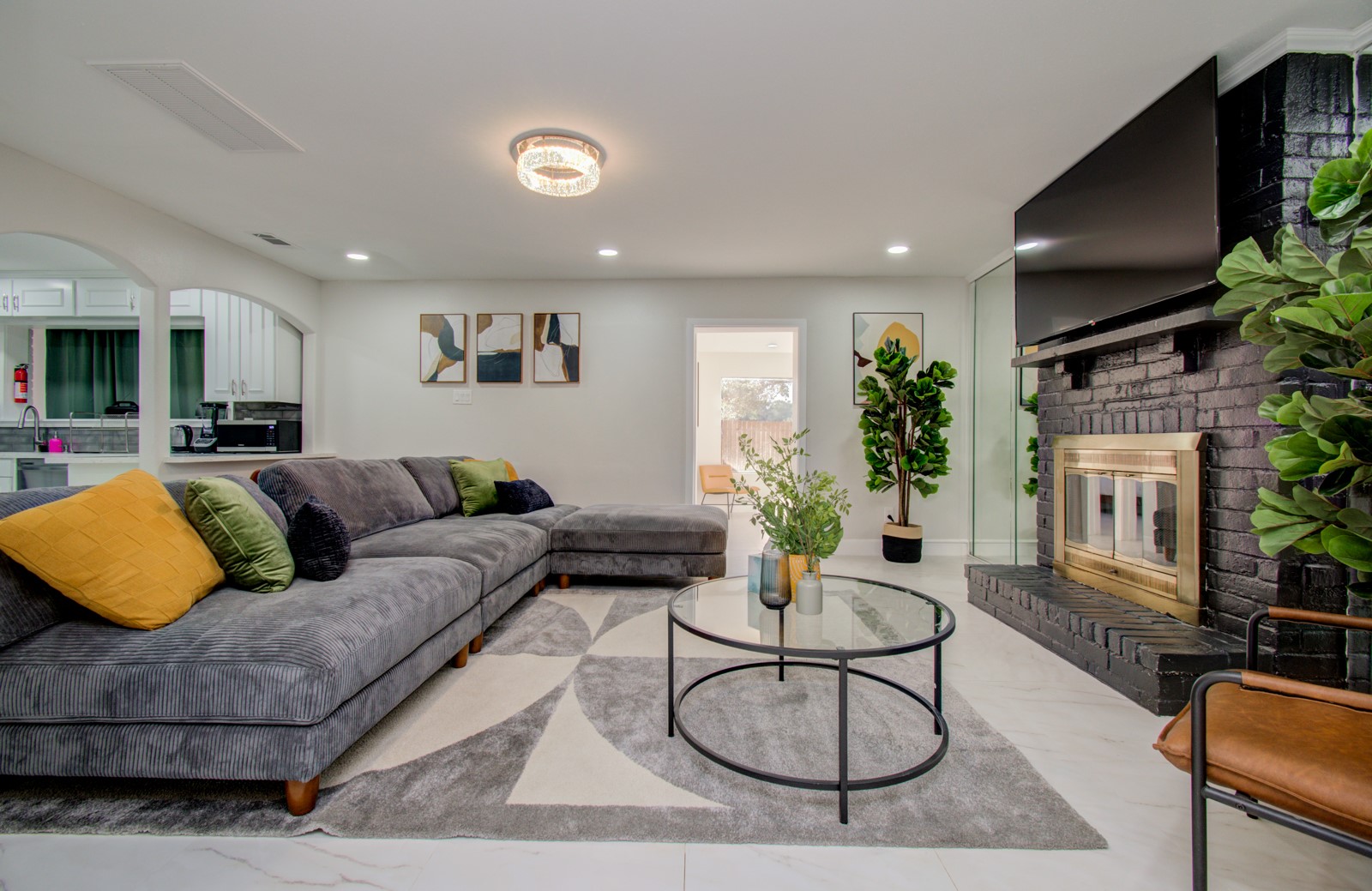 a living room with furniture a flat screen tv and a potted plant