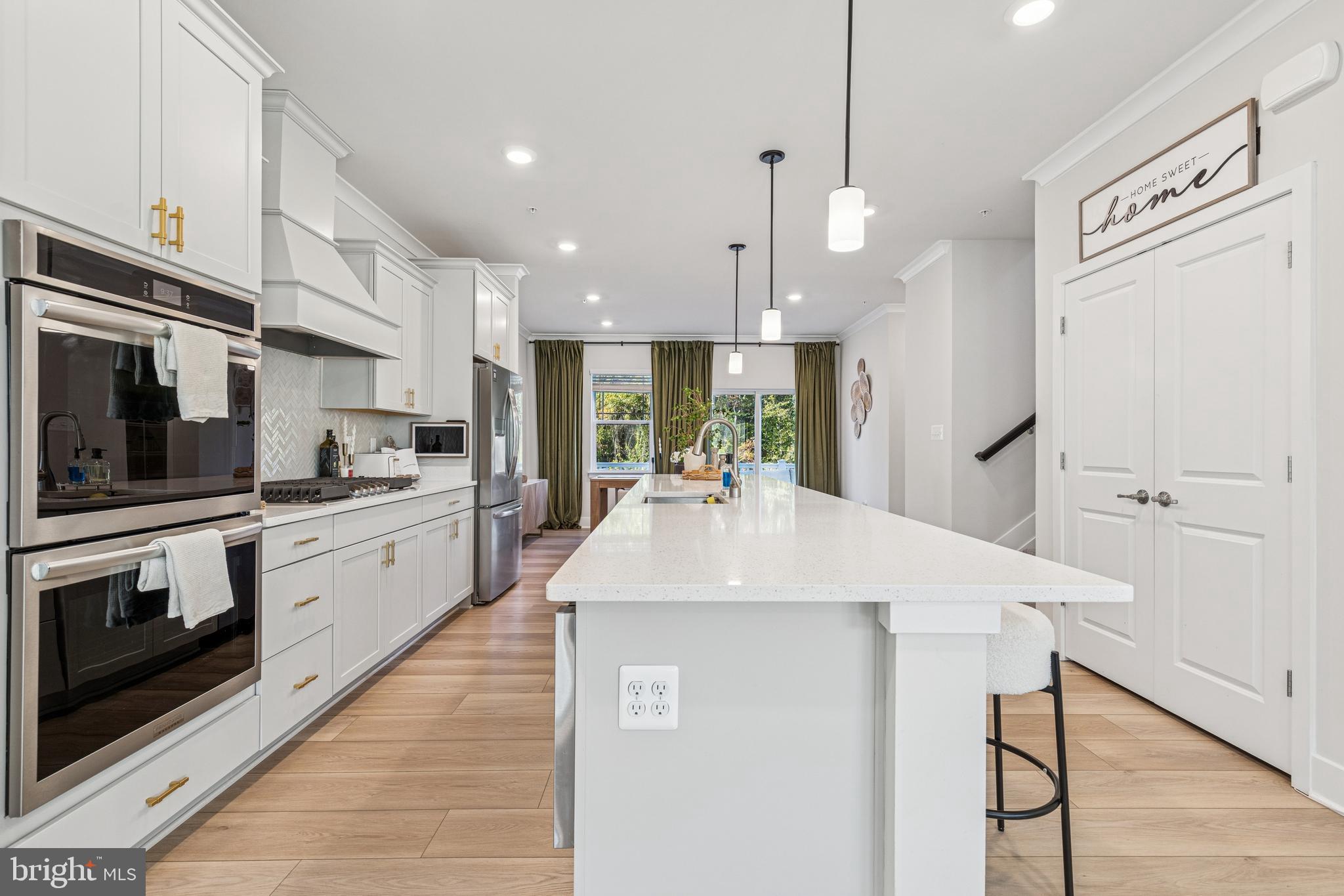 2218 Partin Road Baltimore, MD 21244 - Photo 11 of 62 a kitchen with stainless steel appliances kitchen island granite countertop a refrigerator a stove and white cabinets with wooden floor