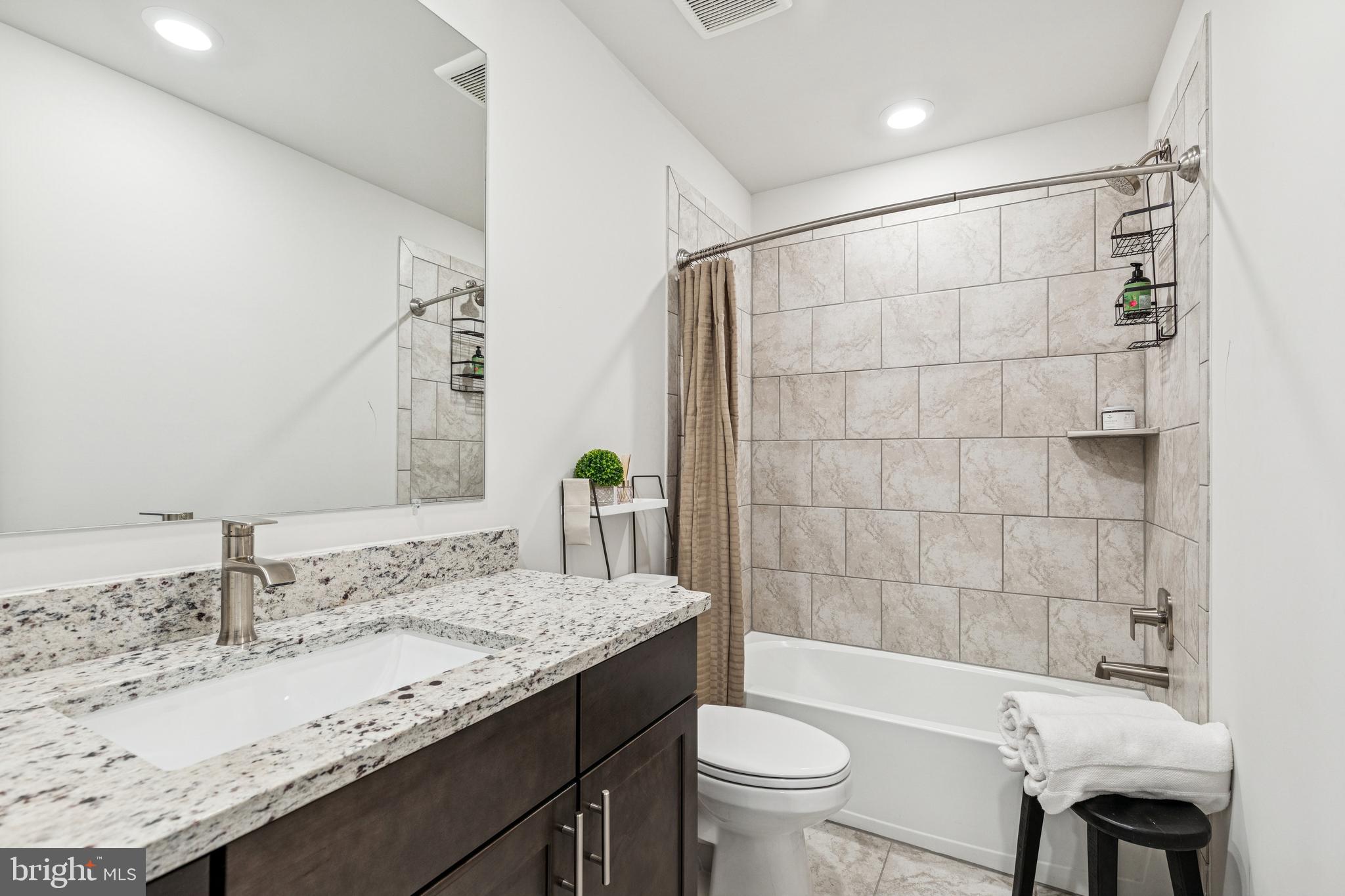2218 Partin Road Baltimore, MD 21244 - Photo 36 of 62 a bathroom with a granite countertop bathtub sink vanity mirror and toilet