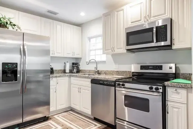 a kitchen with stainless steel appliances granite countertop a stove a microwave and a refrigerator