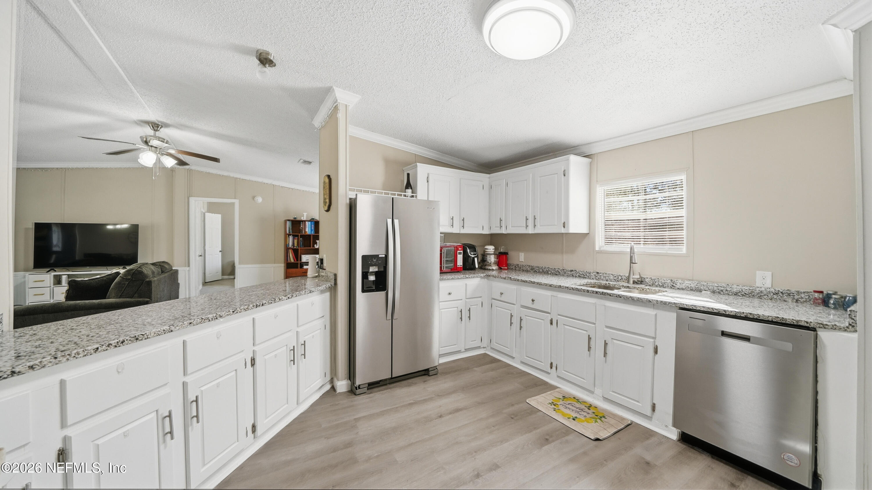 85324 Lil William Road Fernandina Beach, FL 32034 - Photo 11 of 36 a kitchen with white cabinets and stainless steel appliances