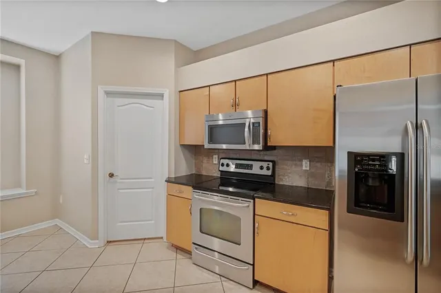 a kitchen with stainless steel appliances a refrigerator stove and microwave
