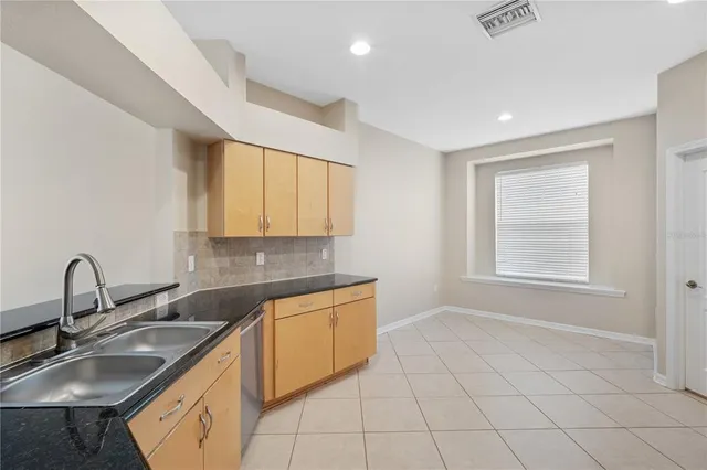 a kitchen with sink a window and cabinets