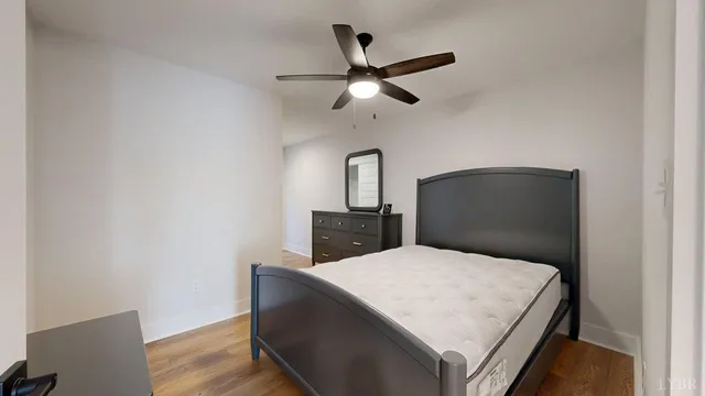 a bedroom with a bed and wooden floor