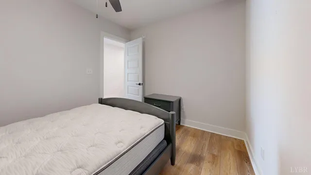 a bedroom with a bed and wooden floor