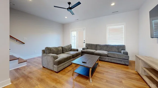 a living room with furniture and a wooden floor