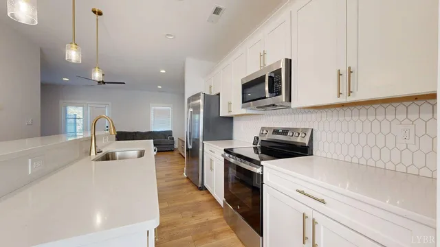 a kitchen with stainless steel appliances granite countertop a stove a sink and a microwave