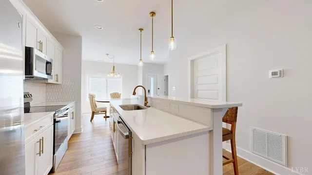 a kitchen with stainless steel appliances a sink a stove and a wooden floors