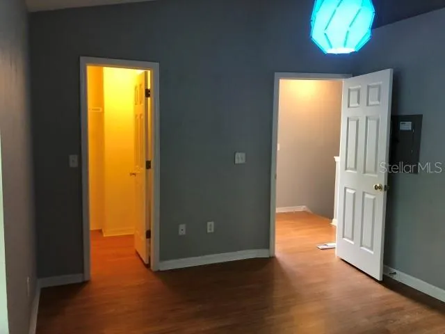 a view of a hallway with wooden floor and a dining room
