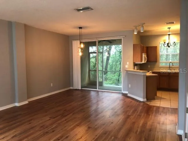 an empty room with wooden floor and outdoor view
