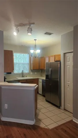 a view of a kitchen with stainless steel appliances granite countertop a refrigerator and a sink