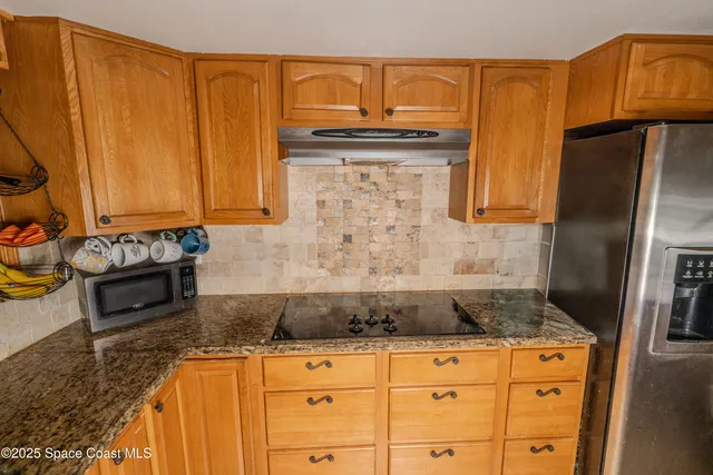 a kitchen with granite countertop a sink a stove and cabinets