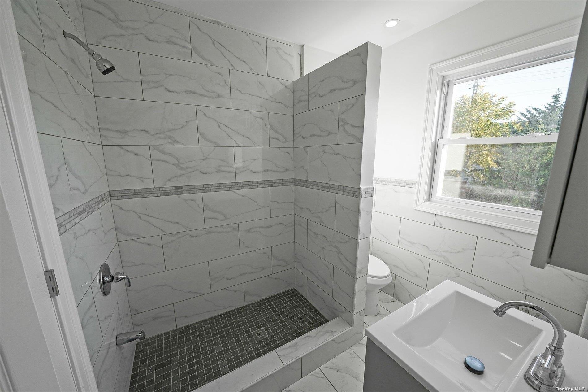 247-14 137th Road Queens, NY 11422 - Photo 15 of 34 a bathroom with a sink and shower
