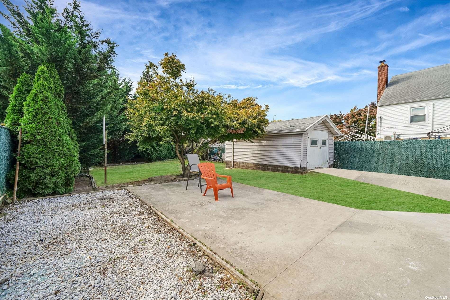 247-14 137th Road Queens, NY 11422 - Photo 3 of 34 a backyard of a house with table and chairs