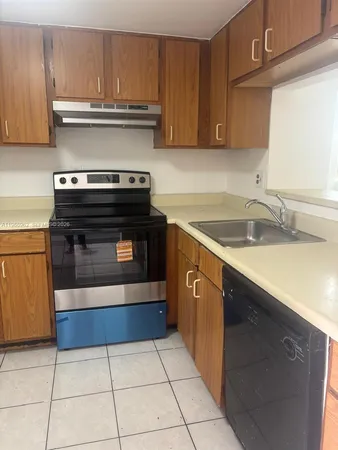 a kitchen with granite countertop a stove top oven and cabinets