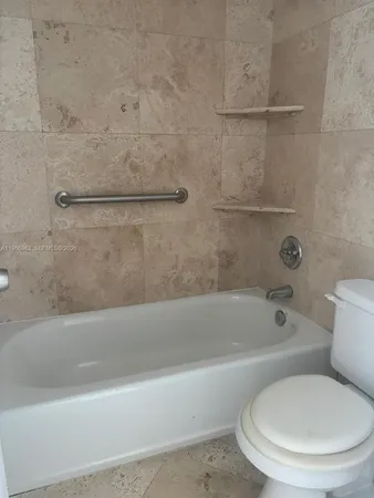 a white bath tub sitting next to a white toilet and sink