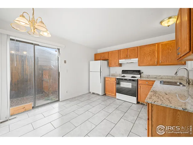a kitchen with granite countertop a sink cabinets and stainless steel appliances