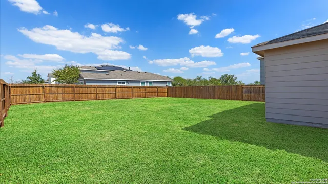 a front view of house with yard and trees in the background
