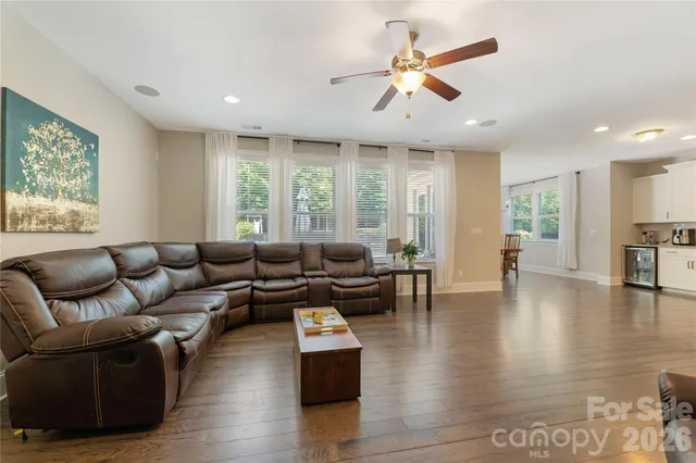 a living room with furniture and a ceiling fan