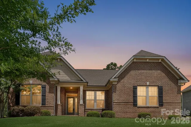 a kitchen with stainless steel appliances kitchen island granite countertop a dining table chairs and white cabinets