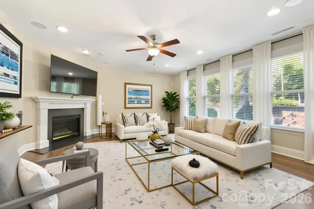 a living room with furniture a potted plant and a large window