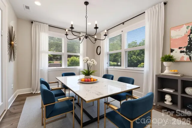 a kitchen with stainless steel appliances kitchen island granite countertop a stove a refrigerator a white table and chairs with wooden floor