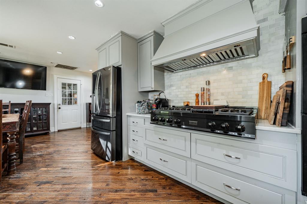 970 North Country Lane Rockwall, TX 75087 - Photo 6 of 40 a kitchen with granite countertop a refrigerator and a stove top oven