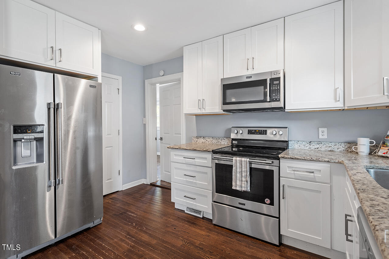 2229 Sheffield Road Raleigh, NC 27610 - Photo 11 of 30 a kitchen with stainless steel appliances granite countertop a stove a refrigerator and a microwave