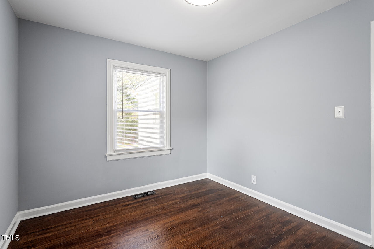 2229 Sheffield Road Raleigh, NC 27610 - Photo 15 of 30 a view of an empty room with wooden floor and a window