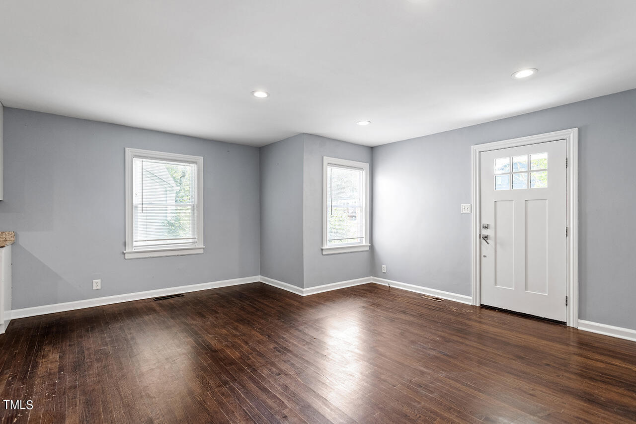 2229 Sheffield Road Raleigh, NC 27610 - Photo 8 of 30 a view of an empty room with wooden floor and a window