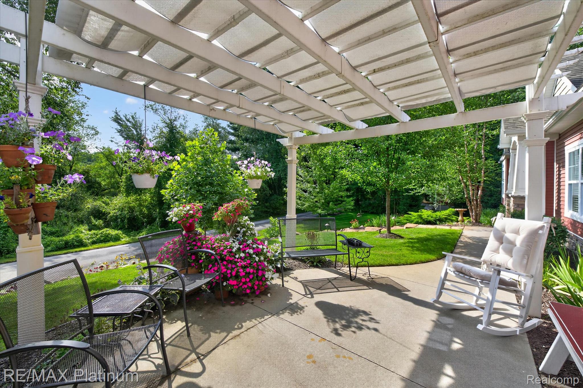 2676 Crooked Lake Road Howell, MI 48843 - Photo 52 of 60 Expansive concrete patio featuring a white pergola structure providing shaded outdoor living space