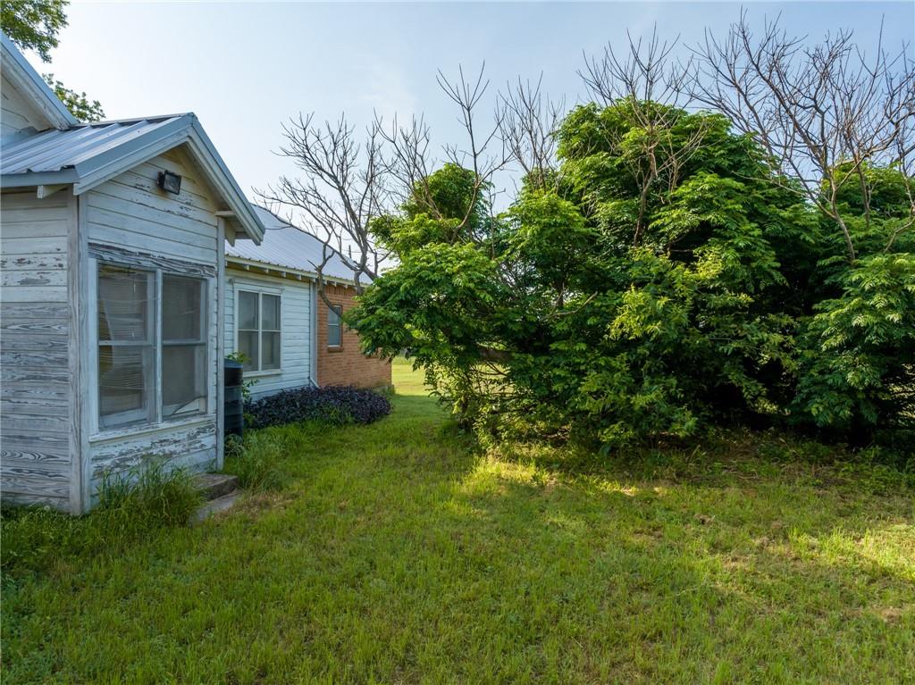 16401 Cedar Rock Parkway Crawford, TX 76638 - Photo 72 of 81 a view of a backyard with plants and large tree