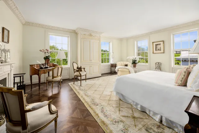 a large bedroom with wooden floor and furniture
