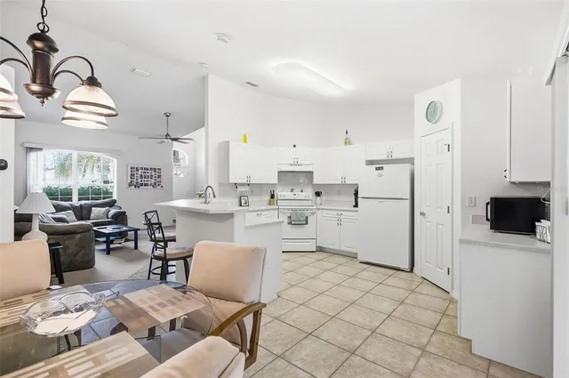 a kitchen with a dining table chairs refrigerator and sink