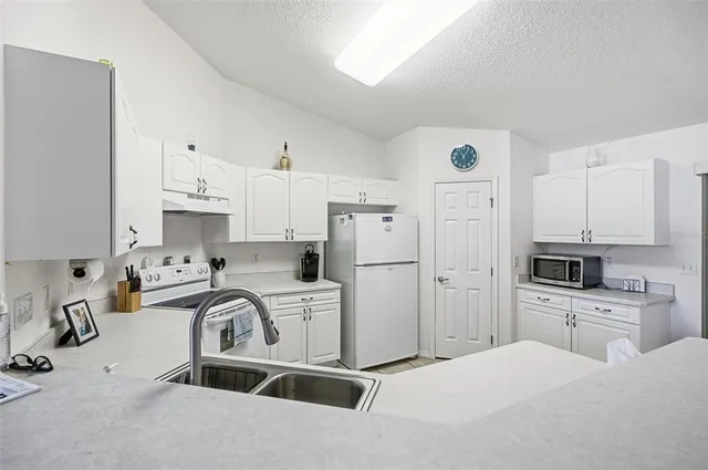 a kitchen with cabinets appliances a sink and a counter top