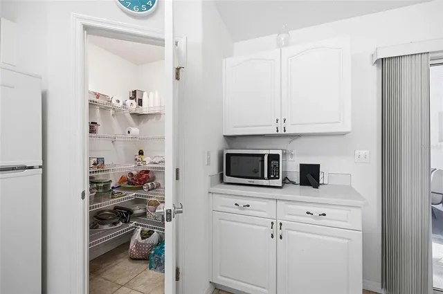 a kitchen with white cabinets a sink a stove and a refrigerator