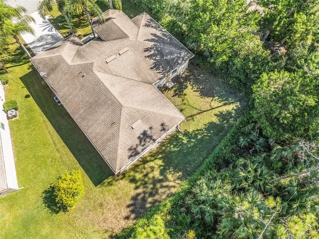 an aerial view of residential house with outdoor space and trees all around