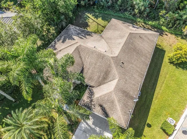an aerial view of residential houses with outdoor space and trees