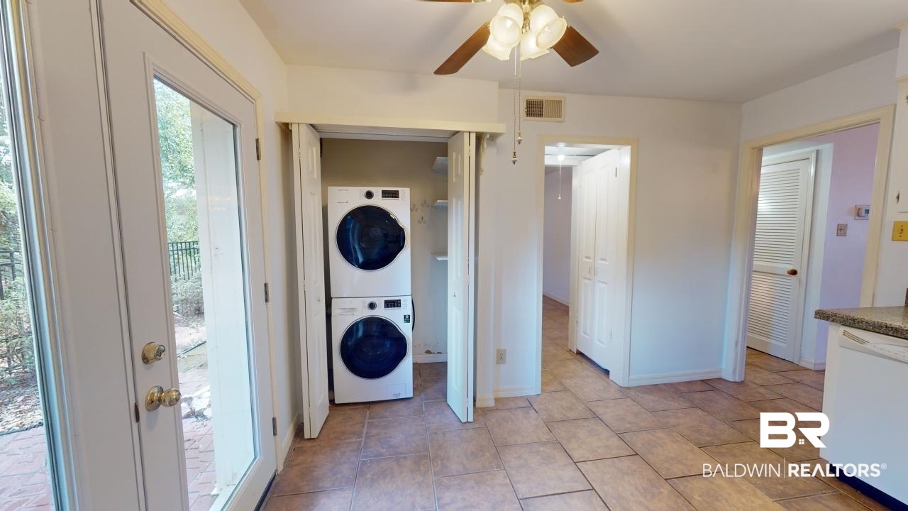 4009 Old Shell Road, Unit C13 Mobile, AL 36608 - Photo 13 of 32 Laundry area featuring stacked washing machine and dryer, a ceiling fan, and baseboards